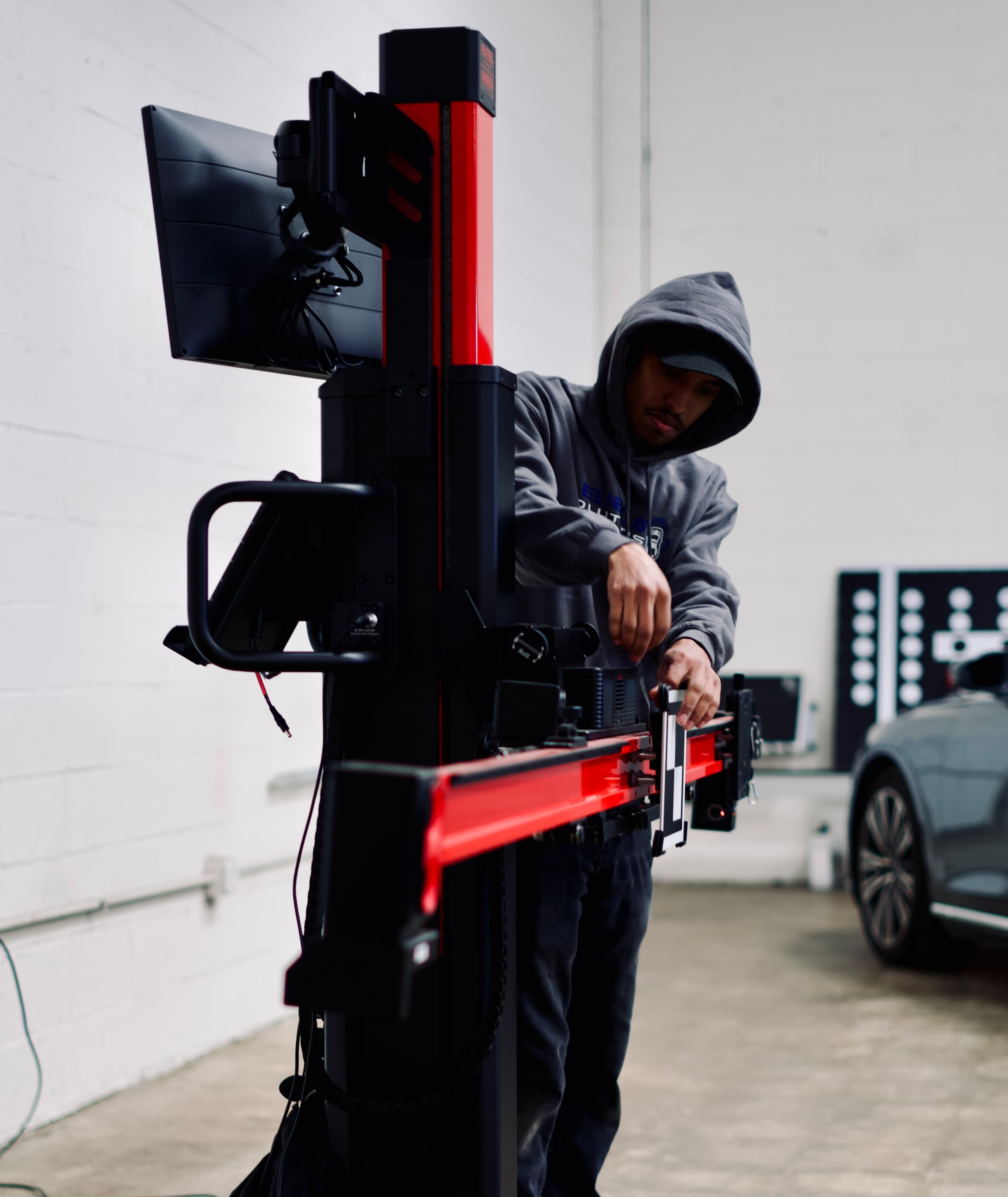 A Level 5 Solutions technician mounting an ADAS calibration target on the frame in the Springfield shop